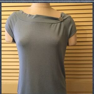 EUC blue top with asymmetrical neckline and brooch by Rena Rowan
